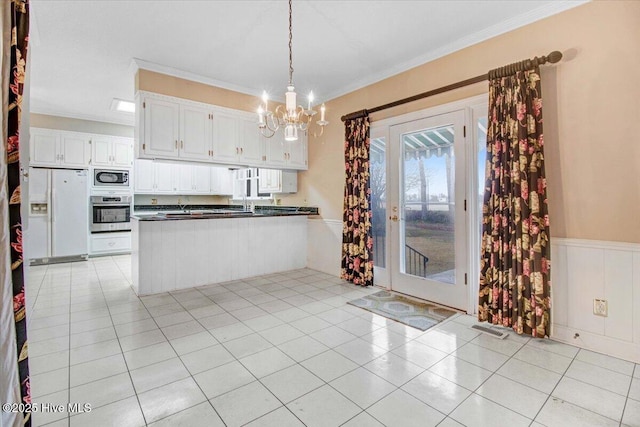 kitchen with crown molding, hanging light fixtures, kitchen peninsula, stainless steel appliances, and white cabinets