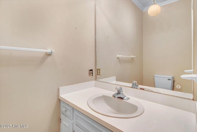 bathroom with crown molding, vanity, and toilet