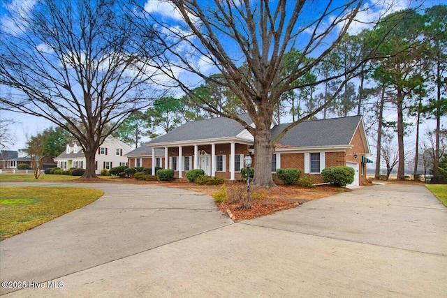 view of front of house with a garage, a front lawn, and covered porch