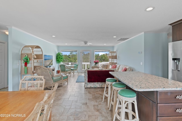 kitchen with crown molding, ceiling fan, and a kitchen island