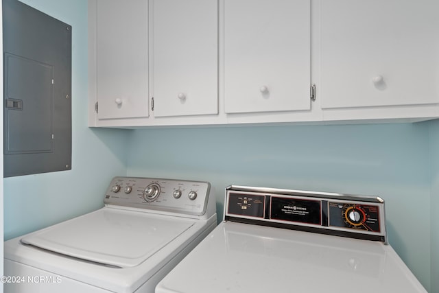 laundry area with electric panel, cabinets, and washing machine and clothes dryer