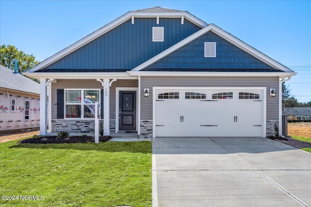 craftsman-style home featuring a garage, a porch, and a front yard