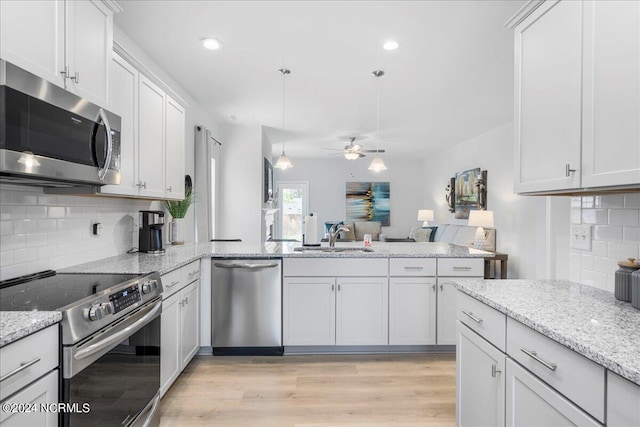 kitchen with appliances with stainless steel finishes, white cabinetry, tasteful backsplash, and ceiling fan