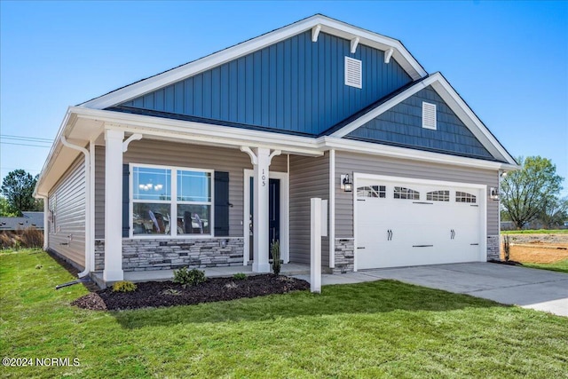 craftsman house featuring a garage, a front yard, and covered porch