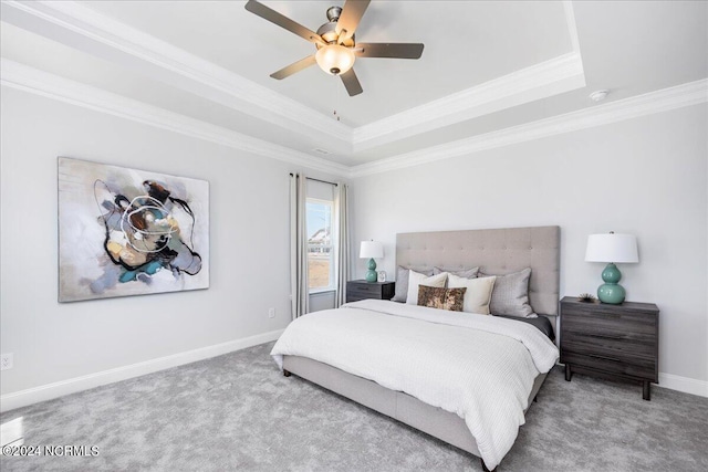 carpeted bedroom featuring a raised ceiling, ceiling fan, and ornamental molding