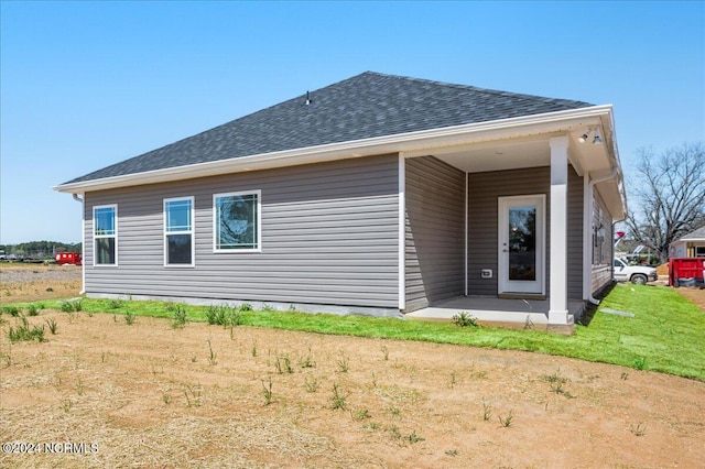 rear view of house featuring a yard