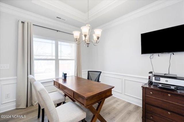 interior space featuring ornamental molding, a raised ceiling, an inviting chandelier, and light hardwood / wood-style floors