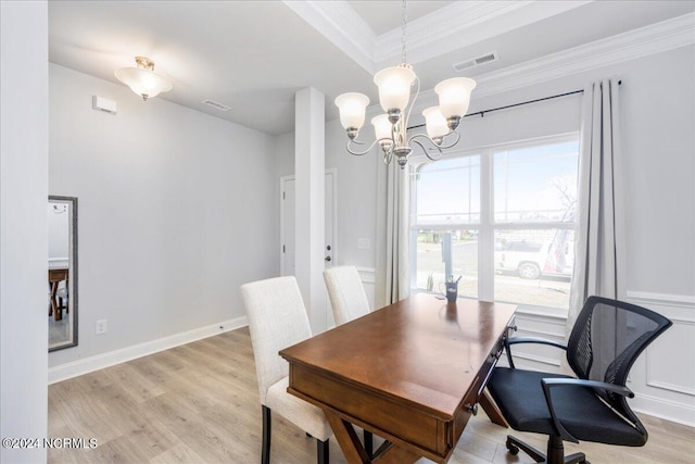 dining space featuring crown molding, a notable chandelier, and light hardwood / wood-style floors