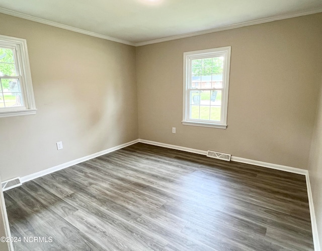 empty room with crown molding and dark hardwood / wood-style flooring