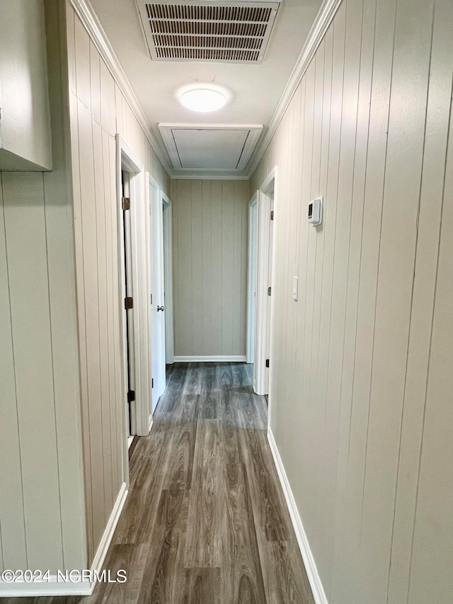 hallway with ornamental molding, wooden walls, and dark hardwood / wood-style floors