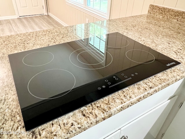 interior details featuring black electric cooktop and light hardwood / wood-style flooring