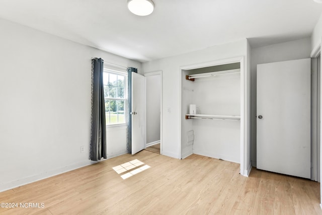 unfurnished bedroom featuring light hardwood / wood-style flooring and a closet