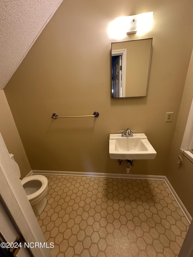 half bathroom featuring toilet and a sink