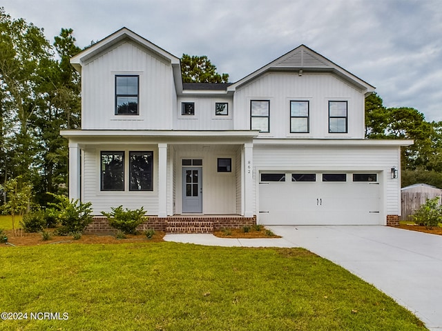 modern inspired farmhouse with a garage, covered porch, and a front yard