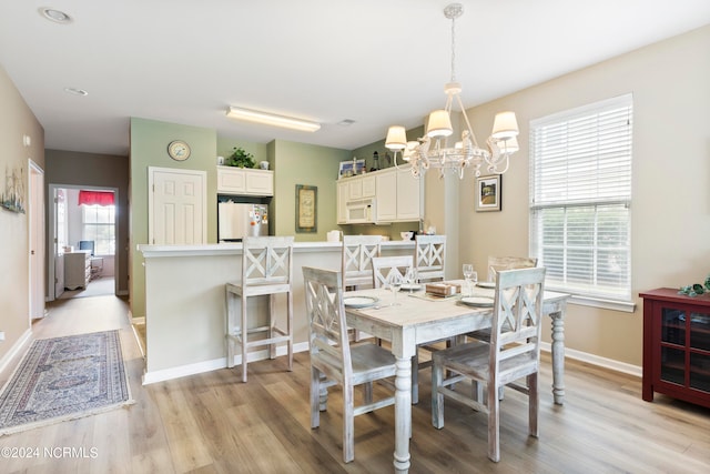 dining space featuring an inviting chandelier, light wood-type flooring, and a wealth of natural light