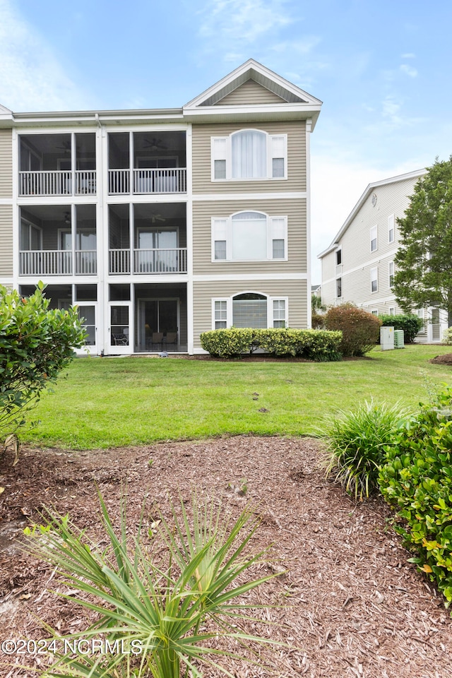 back of property featuring a balcony and a yard