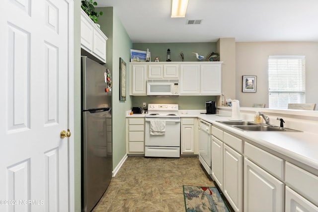 kitchen featuring white appliances, sink, kitchen peninsula, and white cabinets