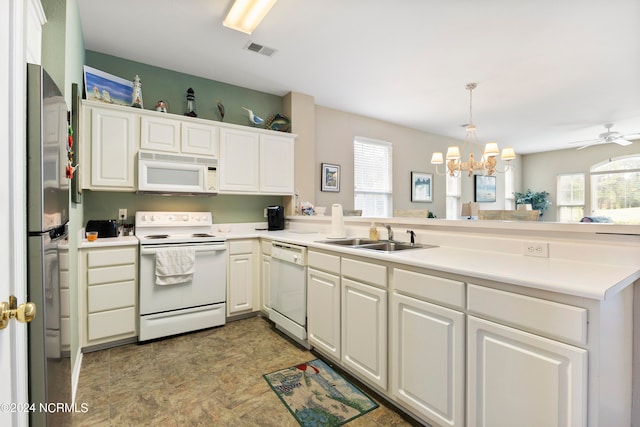 kitchen with sink, ceiling fan with notable chandelier, white cabinets, kitchen peninsula, and white appliances