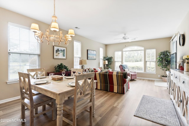 dining area featuring ceiling fan with notable chandelier and light hardwood / wood-style floors