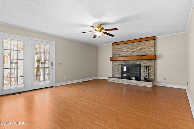 unfurnished living room with a textured ceiling, wood-type flooring, a fireplace, and ceiling fan