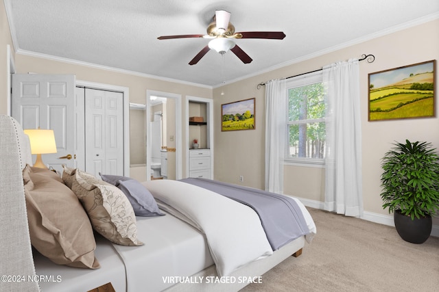 carpeted bedroom with ceiling fan, ornamental molding, a textured ceiling, a closet, and ensuite bath