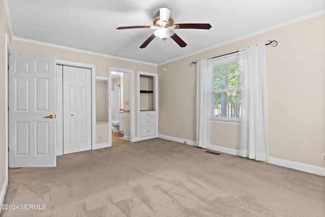 unfurnished bedroom with light carpet, connected bathroom, ceiling fan, and crown molding