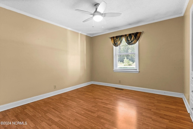 spare room featuring a textured ceiling, wood-type flooring, ornamental molding, and ceiling fan