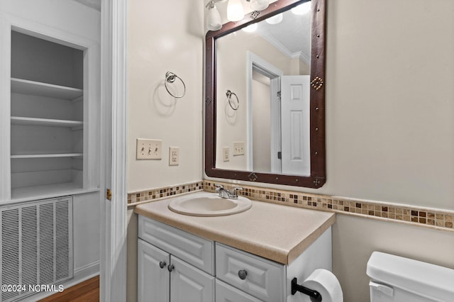 bathroom with vanity, crown molding, toilet, and hardwood / wood-style flooring