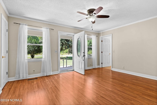 empty room featuring ceiling fan, a textured ceiling, plenty of natural light, and hardwood / wood-style floors