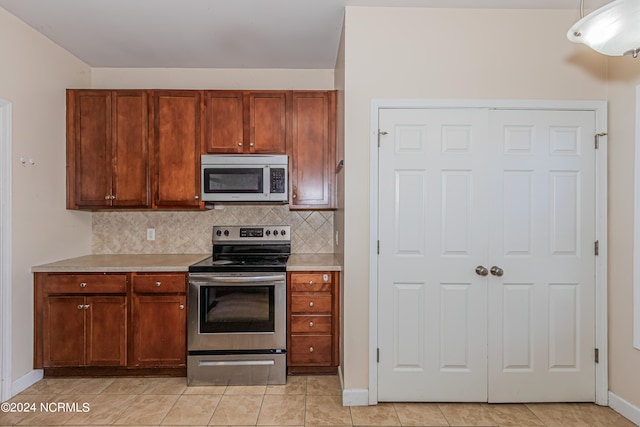 kitchen with decorative backsplash, light tile patterned flooring, and stainless steel appliances