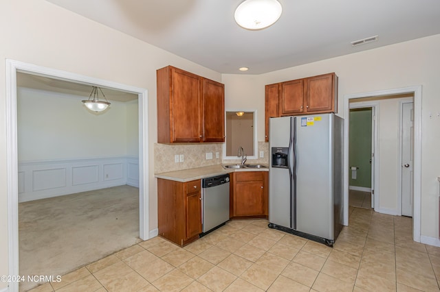 kitchen with light carpet, tasteful backsplash, stainless steel appliances, sink, and decorative light fixtures