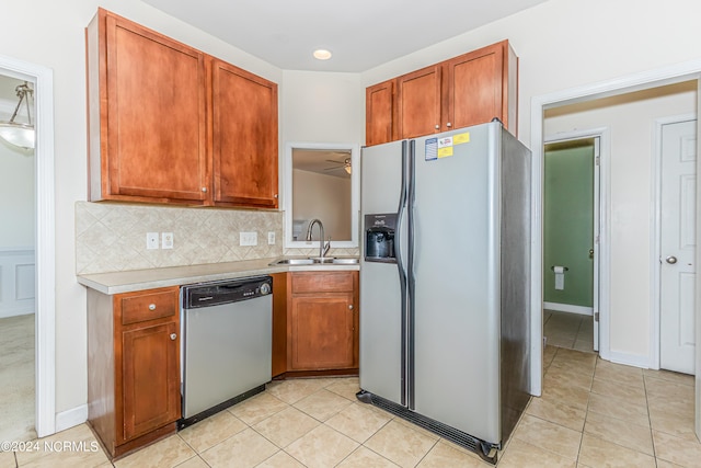 kitchen with appliances with stainless steel finishes, light tile patterned flooring, sink, backsplash, and ceiling fan