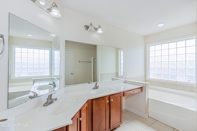 bathroom featuring vanity, a healthy amount of sunlight, a washtub, and tile patterned flooring