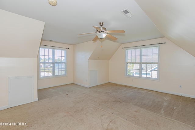 bonus room with light carpet, lofted ceiling, a wealth of natural light, and ceiling fan