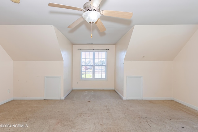 bonus room with lofted ceiling and light colored carpet