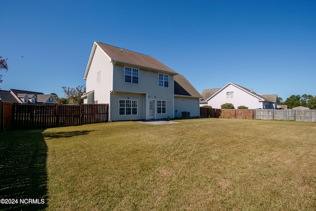 rear view of house with a patio, central air condition unit, and a lawn