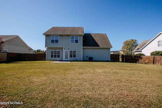 rear view of house featuring a patio, central AC, and a yard