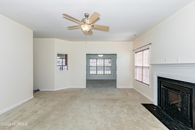 unfurnished living room featuring light carpet and ceiling fan