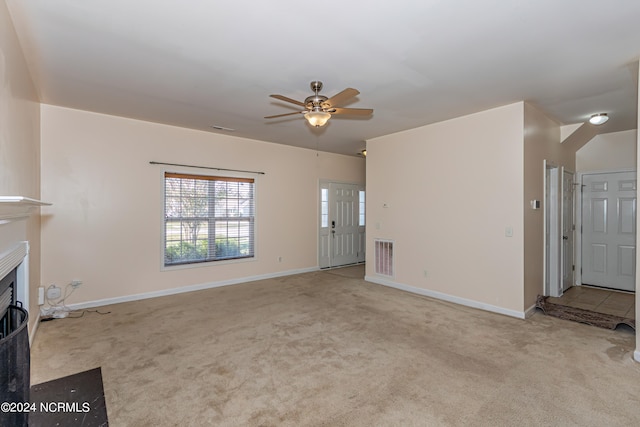 unfurnished living room featuring light colored carpet and ceiling fan