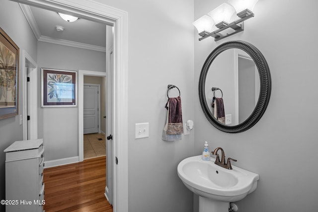 bathroom featuring hardwood / wood-style flooring, sink, and crown molding