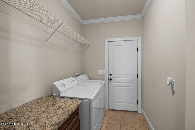 washroom featuring light tile patterned floors, washer and clothes dryer, and crown molding