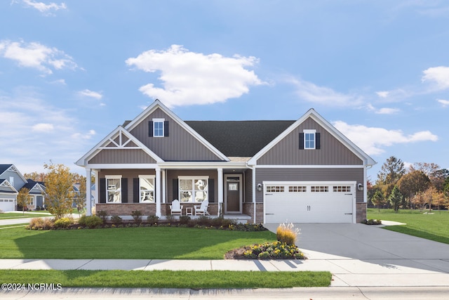 craftsman inspired home featuring a garage, covered porch, and a front yard