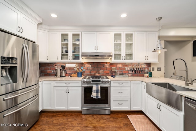 kitchen with appliances with stainless steel finishes, white cabinetry, dark hardwood / wood-style flooring, and decorative light fixtures