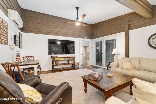 living room featuring a wall mounted AC, a high ceiling, wood-type flooring, ceiling fan, and wooden walls