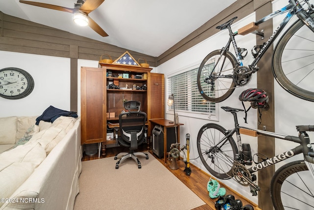 home office featuring lofted ceiling, hardwood / wood-style flooring, and ceiling fan