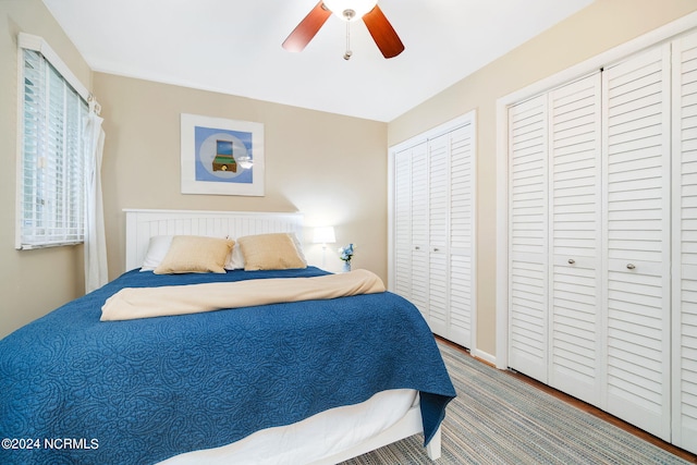 bedroom featuring ceiling fan and multiple closets