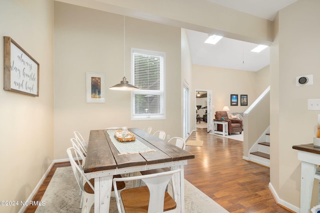 dining room with wood-type flooring and a skylight