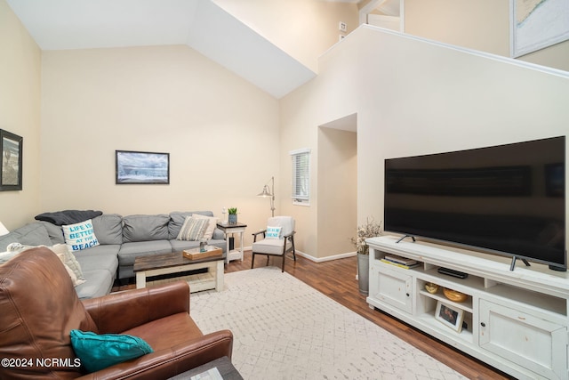 living room featuring dark wood-type flooring and high vaulted ceiling