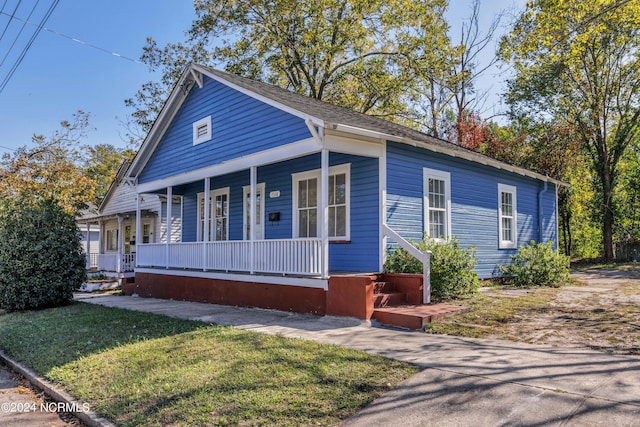 view of front of house with a porch and a front lawn