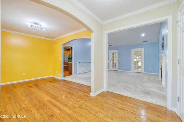 empty room featuring crown molding and light hardwood / wood-style floors